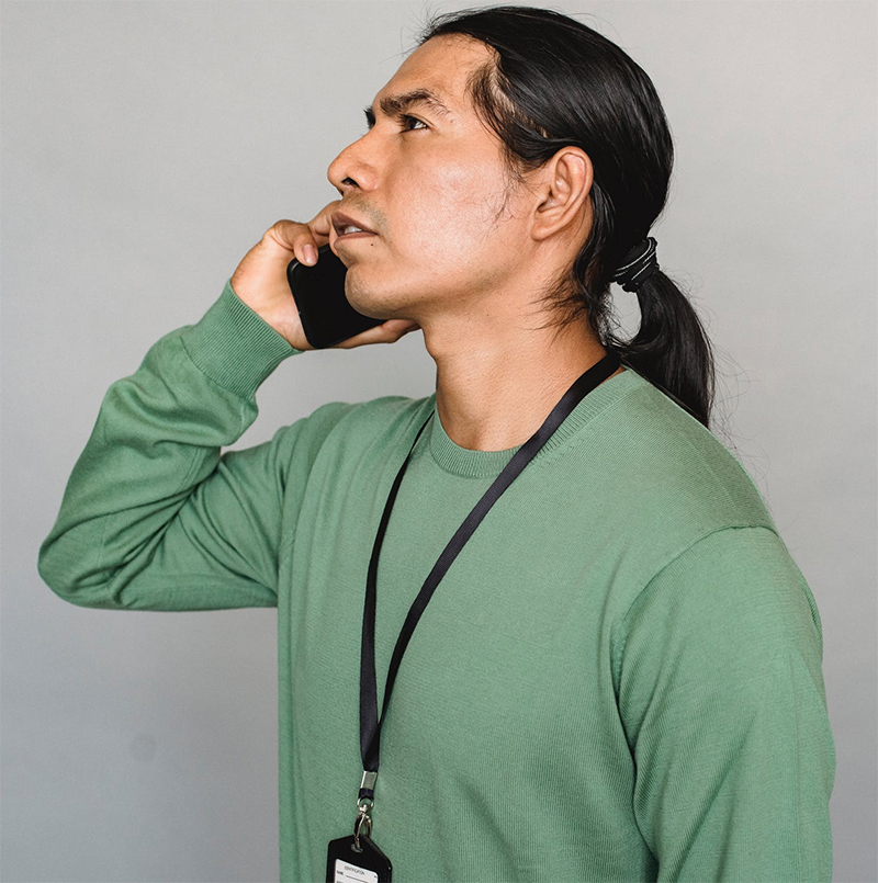 man wearing green sweatshirt using cell phone